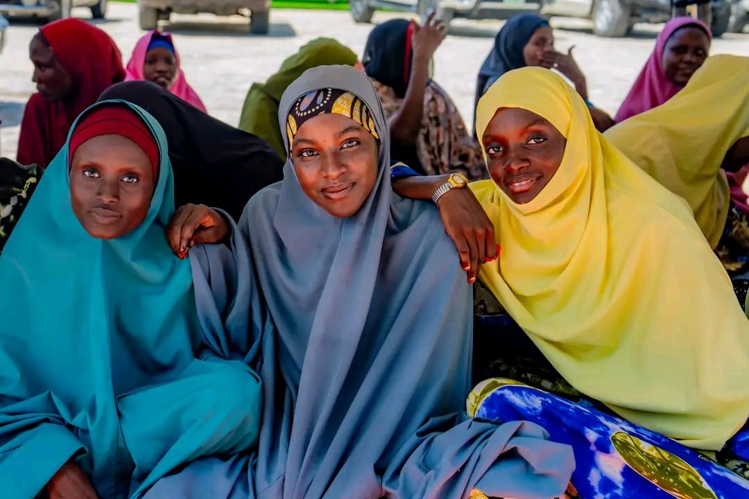 Young women are waiting calmly in a tent for their turn during distribution.