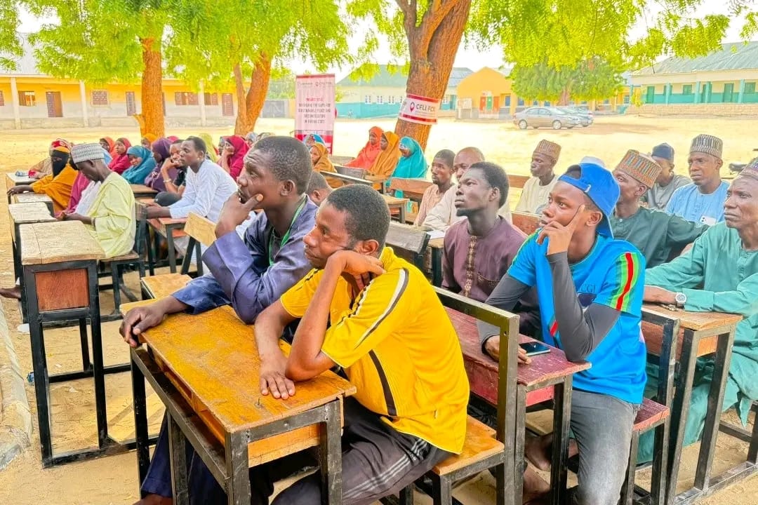 Community members are quietly attending a community outreach session on Transitional Justice.