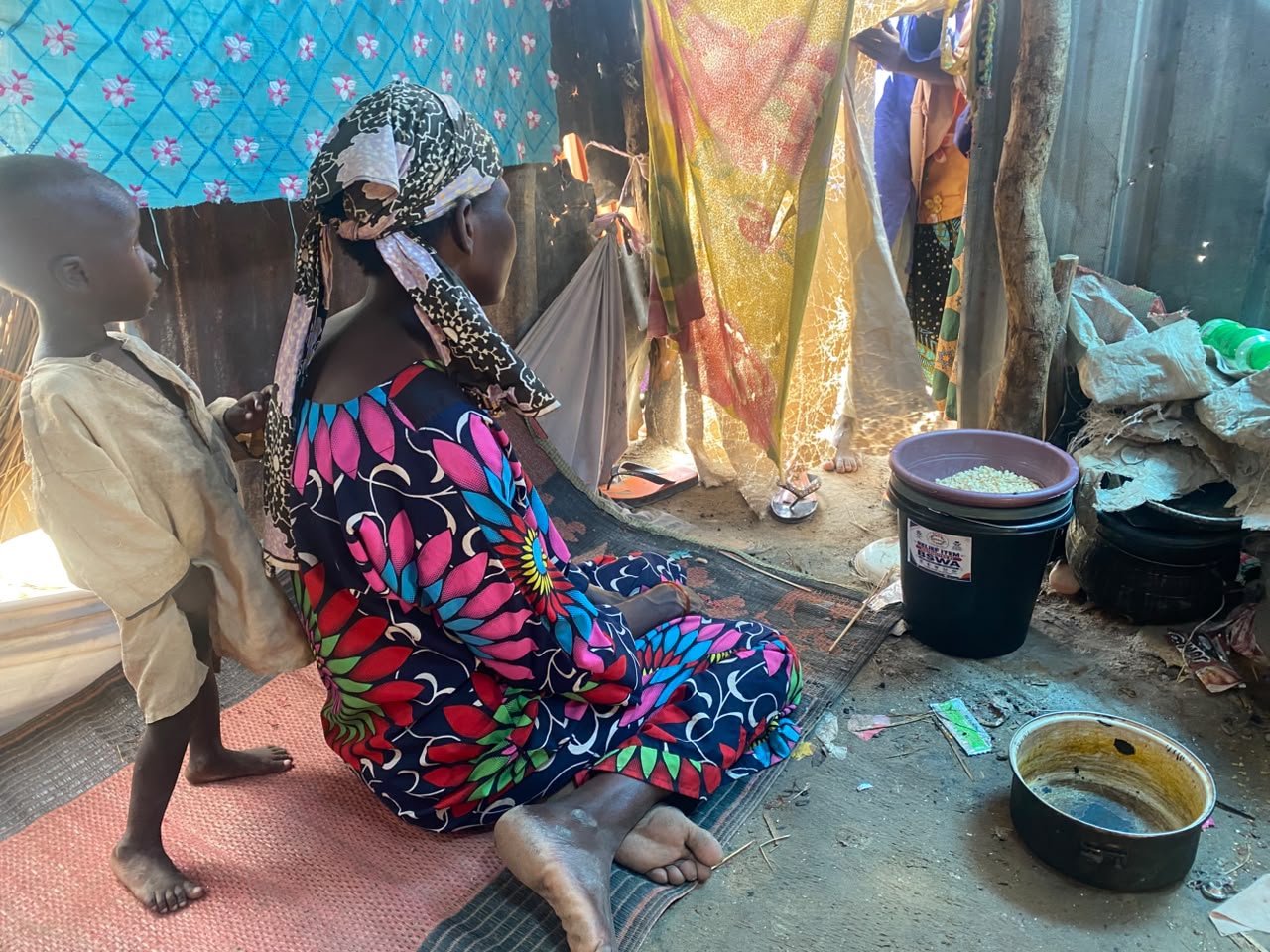A displaced woman sitting quietly inside her tent at Elmiskin Camp in Maiduguri. Photo credit: @Falmataaminamohammed